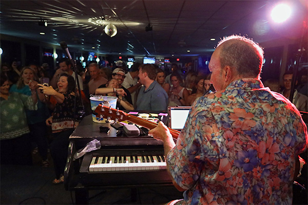 A performer entertaining a happy crowd at a private event on board